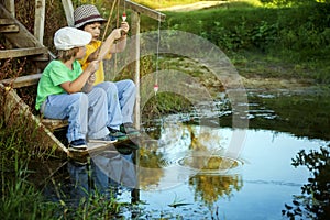 Happy boys go fishing on the river, Two children of the fisherman with a fishing rod on the shore of lake