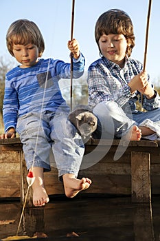 Happy boys go fishing on the river, Two children of the fisherman with a fishing rod on the shore of lake