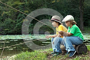 Happy boys go fishing on the river, Two children of the fisherman with a fishing rod on the shore of lake