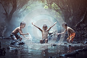 Happy boys has fun playing in the creek