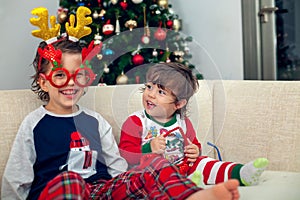 Happy boys playing with Christmas tree in the background