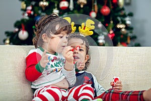 Happy boys playing with Christmas tree in the background