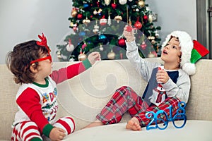 Happy boys playing with Christmas tree in the background