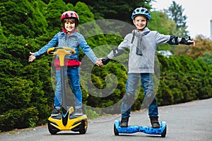 Happy boys riding on hoverboards or gyroscooters outdoor