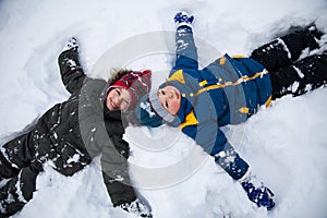 Happy boys in snow play and smile sunny day