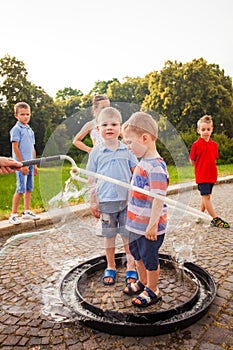 Happy boys standing in big soap bubble together