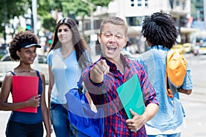 Happy brazilian male student with group of students