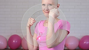 Happy breast cancer survivor woman fighting breast cancer making boxer`s punches -breast cancer awareness concept