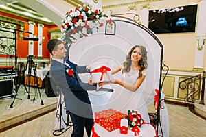 Happy bridal couple with presents at wedding party
