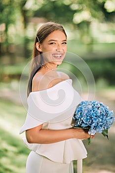 Happy Bride In Beautiful White Dress Holding Bouquet Standing Outside
