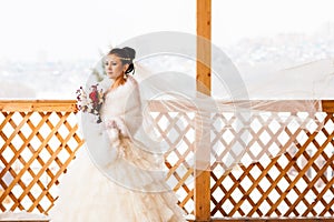 Happy Bride with bouquet waiting for groom in winter wedding day