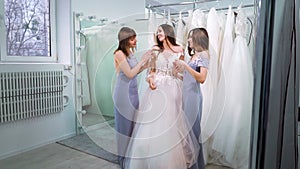 Happy bride with bridesmaids in elegant outfits in wedding salon