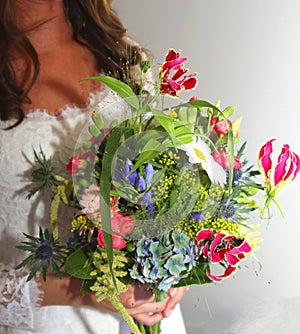 Happy bride with a colorful bridal bouquet at the wedding day