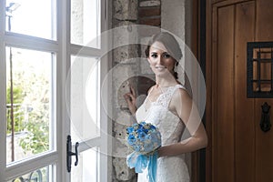 Happy bride in front of window