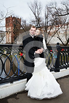 Happy bride and groom on bridge near castle