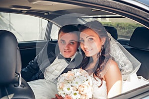 Happy bride and groom in the car