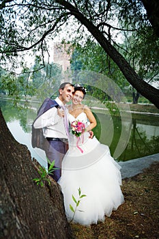 Happy bride and groom on coast of lake