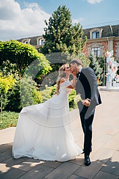 happy bride and groom dance in the park.