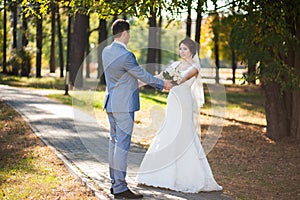 Happy bride, groom dancing in green park, kissing, smiling, laughing. lovers in wedding day. happy young couple in love.