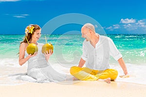 Happy bride and groom drink coconut water and having fun on a tr