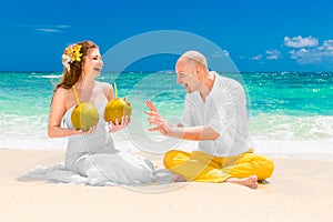 Happy bride and groom drink coconut water and having fun on a tr