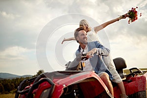 Happy bride and groom enjoying a quad atv vehicle at nature