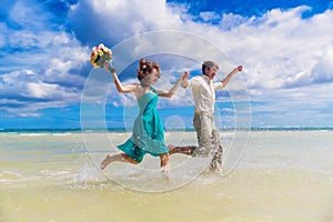 Happy bride and groom having fun on a tropical beach