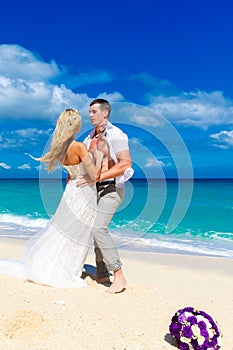 Happy bride and groom having fun on a tropical beach. wedding bo