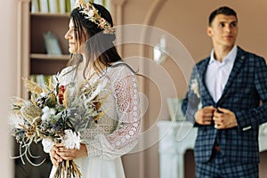 Happy bride and groom holding a bouquet of wedding flowers, Happy young couple, Bride and groom posing and looking at each other