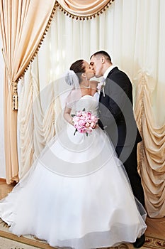 Happy bride and groom kissing on solemn registration