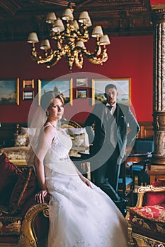 Happy bride and groom in luxury chairs in chic interiors