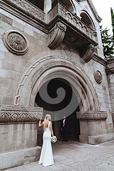 Happy bride and groom near old castle