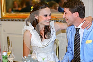 Happy bride and groom smiling look et each other in a restauran