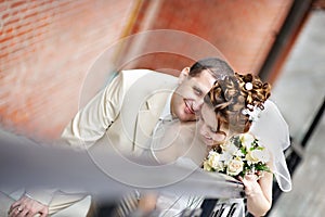 Happy bride and groom on stairs in park
