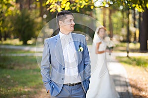 Happy bride, groom standing in green park, kissing, smiling, laughing. lovers in wedding day. happy young couple in love.