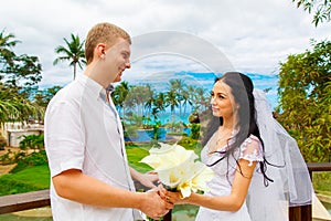 Happy bride and groom standing next to the stone gazebo