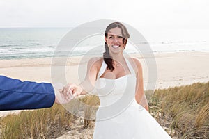 Happy bride and groom on their wedding hugging on the beach