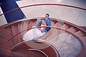 Happy bride and groom on their wedding stand on a wooden ladder