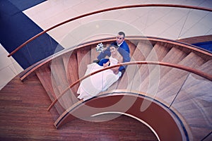 Happy bride and groom on their wedding stand on a wooden ladder