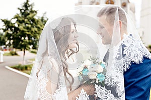 Happy bride and groom under the veil