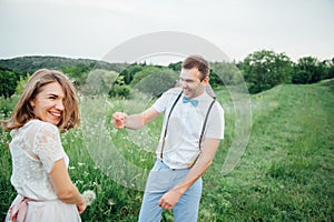 Happy Bride and groom walking on the green grass