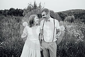 Happy Bride and groom walking on the green grass