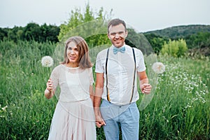 Happy Bride and groom walking on the green grass