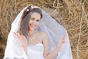 Happy bride near hay