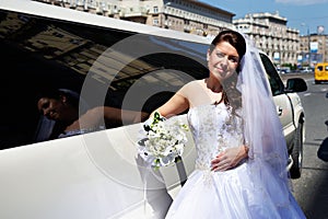 Happy bride near wedding limo