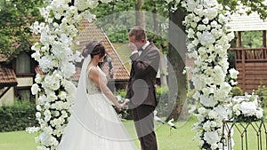 Happy bride reading wedding vows. Bride saying her vows to groom at wedding ceremony. Bride and groom stand together at