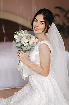 Happy bride sit in wedding dress and smiled. Bridde with bouquet