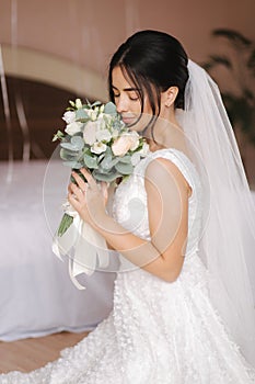 Happy bride sit in wedding dress and smiled. Bridde with bouquet