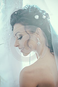 Happy bride smile on wedding day. Sensual woman with professional makeup. Woman with bridal veil on brunette hair