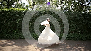 Happy bride spinning in the Park. Bride`s dress. Wedding day.